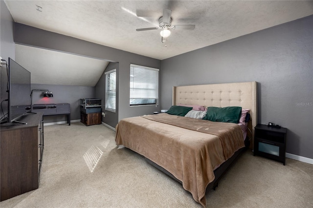 bedroom featuring vaulted ceiling, baseboards, a textured ceiling, a ceiling fan, and light carpet