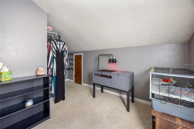 interior space featuring baseboards, vaulted ceiling, and carpet