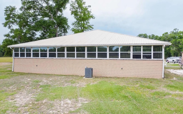 view of property exterior with metal roof and a sunroom