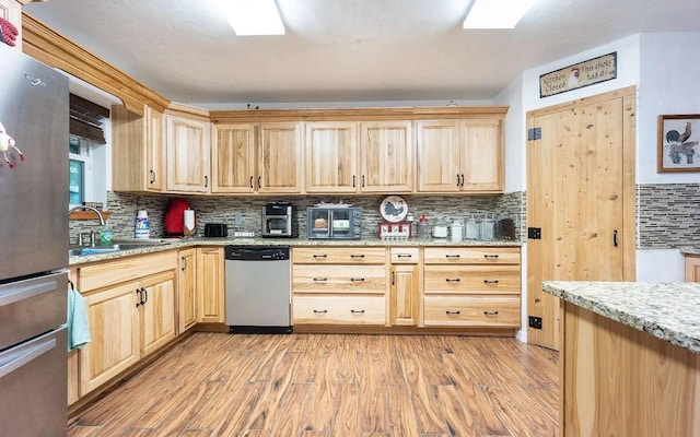 kitchen with light wood-style flooring, light brown cabinets, and stainless steel appliances