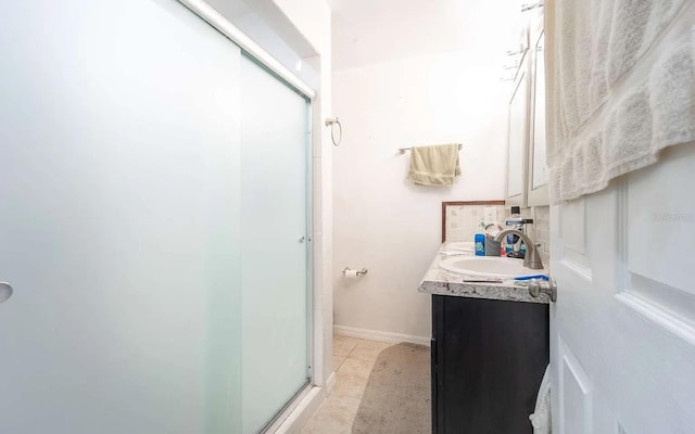 bathroom with tile patterned floors, baseboards, vanity, and a shower stall