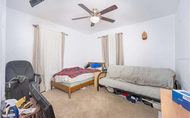 bedroom featuring a ceiling fan, visible vents, and light carpet