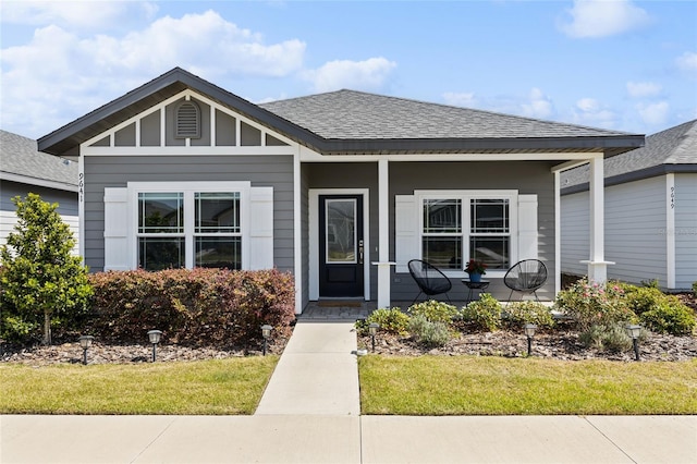 bungalow-style home featuring a porch, roof with shingles, and board and batten siding