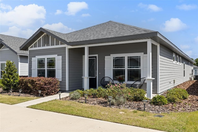 bungalow-style home featuring a porch and roof with shingles