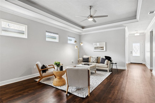 living area with ceiling fan, baseboards, a raised ceiling, and dark wood finished floors