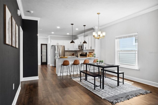 dining area with a chandelier, dark wood-style flooring, ornamental molding, and baseboards