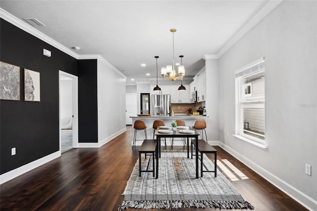 dining space featuring crown molding, dark wood finished floors, and an inviting chandelier