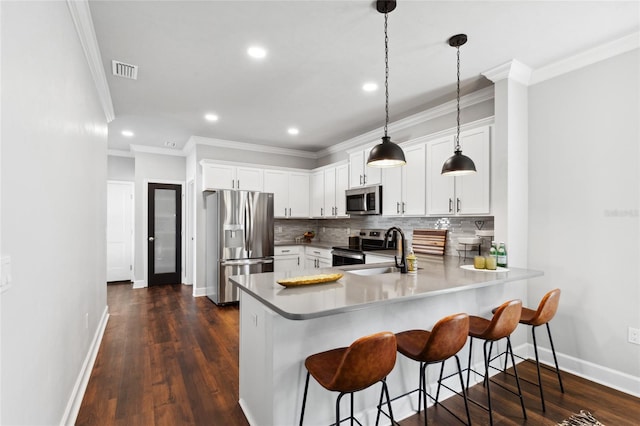 kitchen with stainless steel appliances, visible vents, decorative backsplash, a sink, and a peninsula