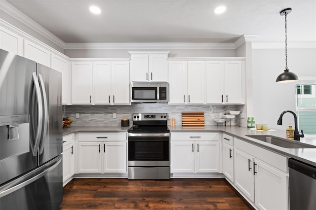 kitchen featuring stainless steel appliances, dark wood-style flooring, a sink, white cabinets, and ornamental molding