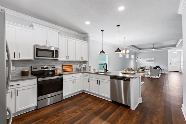 kitchen with stainless steel appliances, a peninsula, a sink, white cabinets, and open floor plan