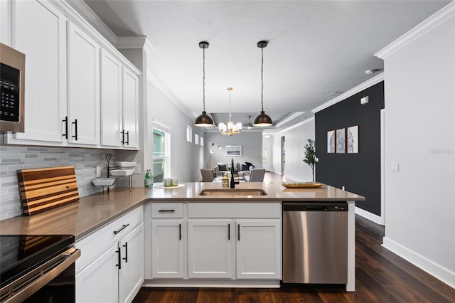 kitchen with white cabinets, open floor plan, a peninsula, stainless steel appliances, and a sink