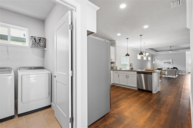 laundry room featuring crown molding, recessed lighting, visible vents, a sink, and washer and dryer