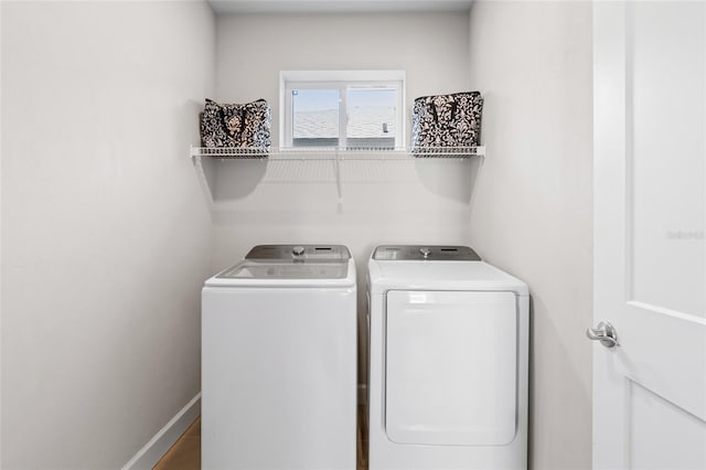 laundry room featuring laundry area, washing machine and dryer, and baseboards