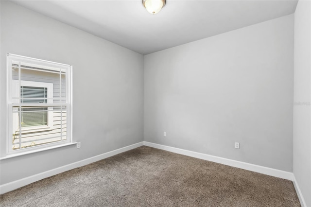 unfurnished room with carpet floors and baseboards