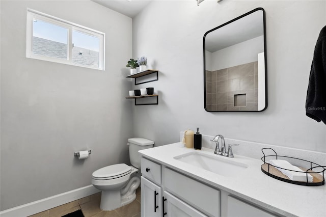 bathroom featuring toilet, tile patterned floors, baseboards, and vanity