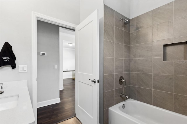 bathroom with shower / tub combination, baseboards, wood finished floors, and vanity