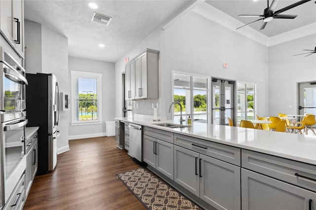 kitchen featuring gray cabinets, light countertops, visible vents, appliances with stainless steel finishes, and a sink