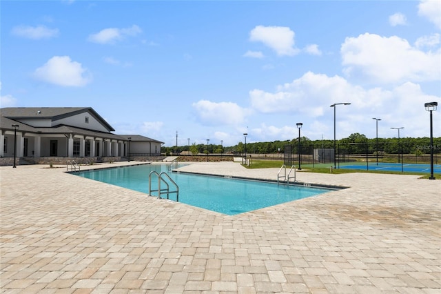 community pool featuring a patio and fence