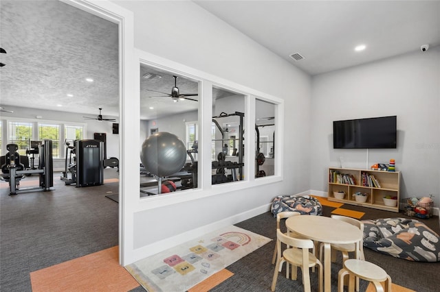 recreation room featuring recessed lighting, visible vents, a ceiling fan, a textured ceiling, and baseboards