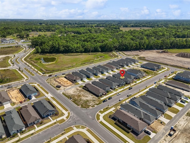 birds eye view of property featuring a forest view and a residential view