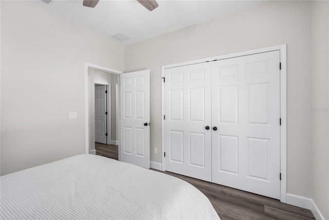 bedroom featuring dark wood finished floors, baseboards, a closet, and ceiling fan