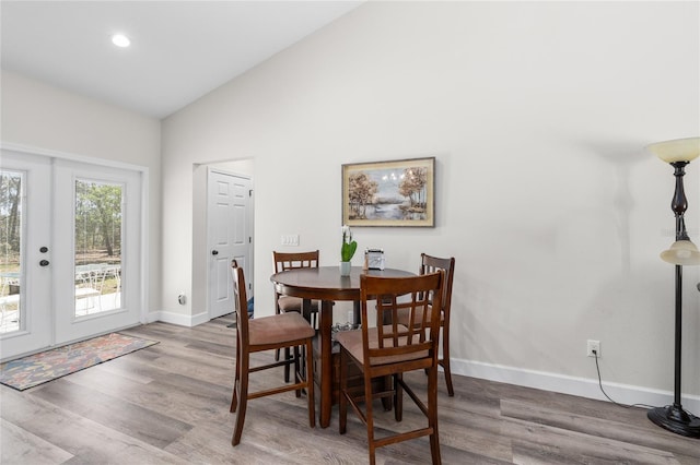 dining room featuring high vaulted ceiling, wood finished floors, recessed lighting, french doors, and baseboards