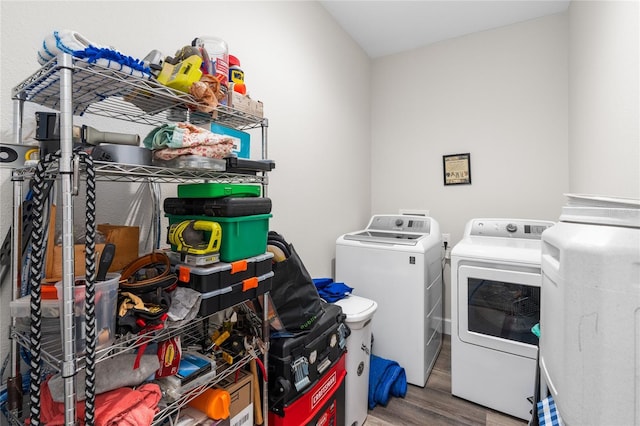 laundry area featuring washer and clothes dryer, laundry area, and wood finished floors