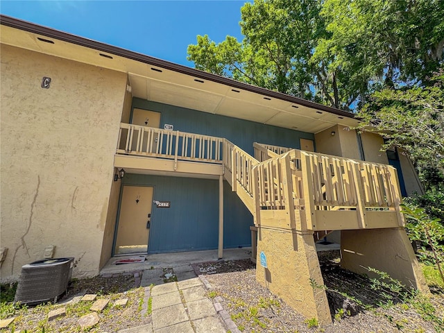 exterior space with cooling unit and stucco siding