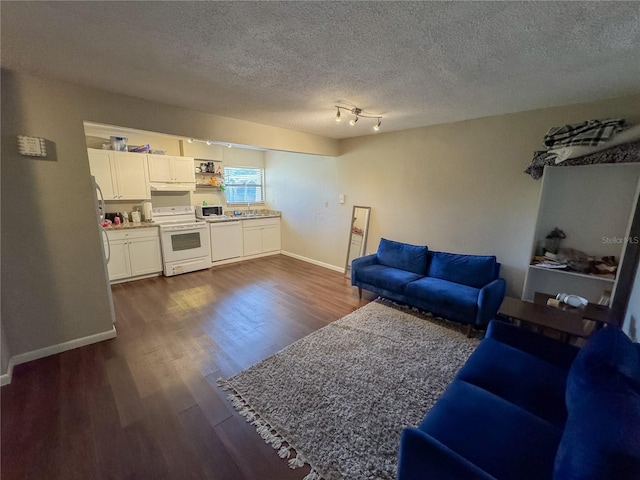 living room with dark wood-type flooring, baseboards, and a textured ceiling