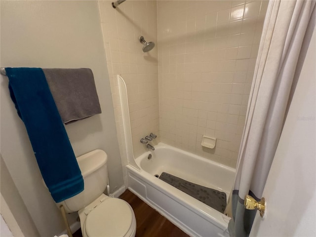 bathroom featuring toilet, wood finished floors, and shower / bath combo with shower curtain