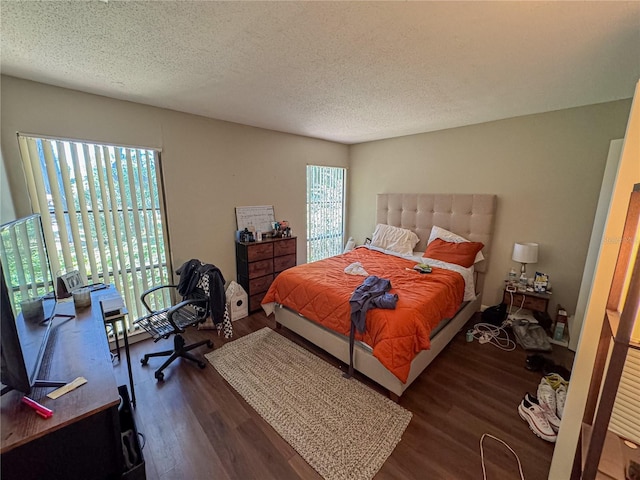 bedroom with a textured ceiling and wood finished floors