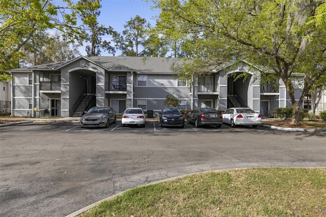 view of building exterior featuring uncovered parking and stairway