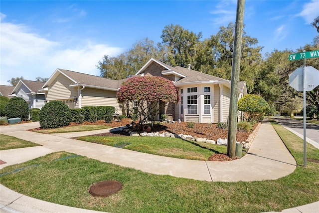 view of front of home featuring brick siding and a front yard