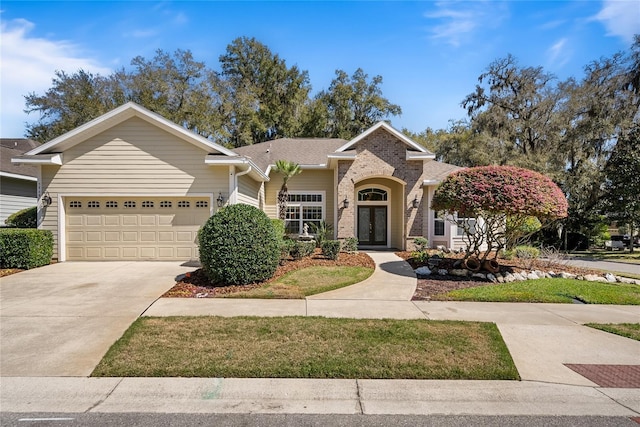 ranch-style house featuring french doors, a garage, concrete driveway, and brick siding