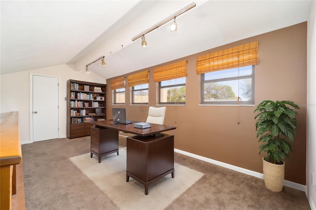office space featuring lofted ceiling with beams, light carpet, baseboards, and rail lighting