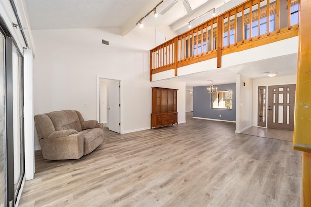 living area featuring an inviting chandelier, wood finished floors, visible vents, and baseboards