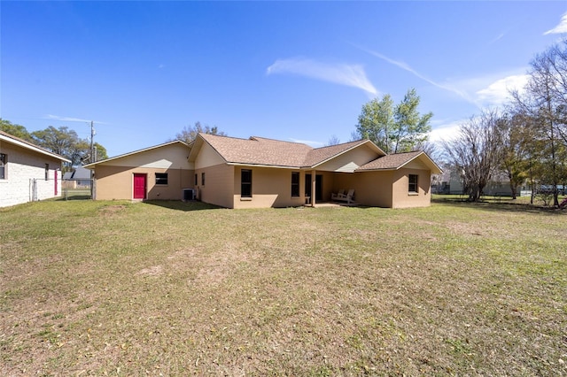 back of property with fence, cooling unit, a yard, and a shingled roof