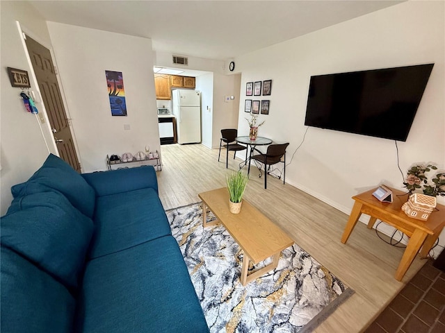 living area featuring visible vents, baseboards, and light wood-style flooring