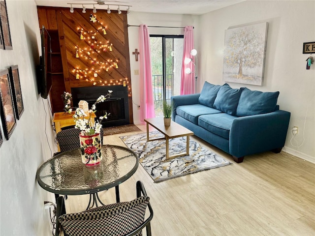 1515 NW 29th Rd Unit A7, Gainesville, FL 32605 - living room with baseboards, a large fireplace, wood finished floors, and track lighting