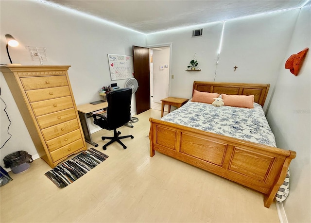 bedroom with light wood-style flooring and visible vents