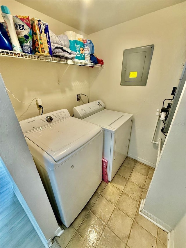 laundry room with light tile patterned floors, baseboards, laundry area, electric panel, and washer and clothes dryer