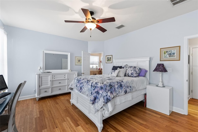 bedroom with a ceiling fan, light wood-type flooring, visible vents, and baseboards