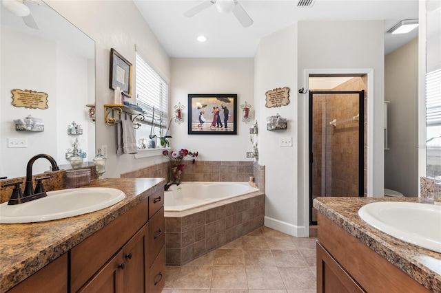 bathroom featuring tile patterned flooring, a shower stall, two vanities, and a sink