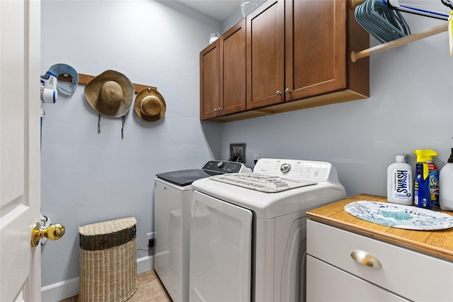 laundry room with baseboards, cabinet space, washing machine and clothes dryer, and light tile patterned flooring