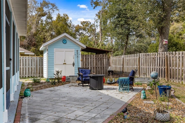 view of patio / terrace with an outbuilding, a storage unit, and a fenced backyard