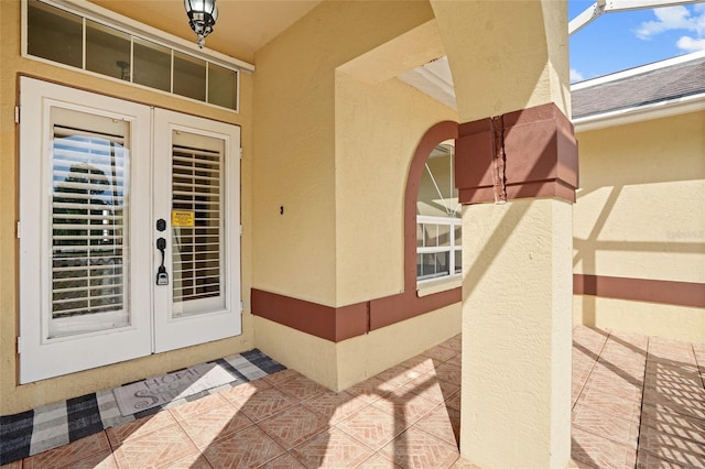 view of exterior entry featuring stucco siding and french doors