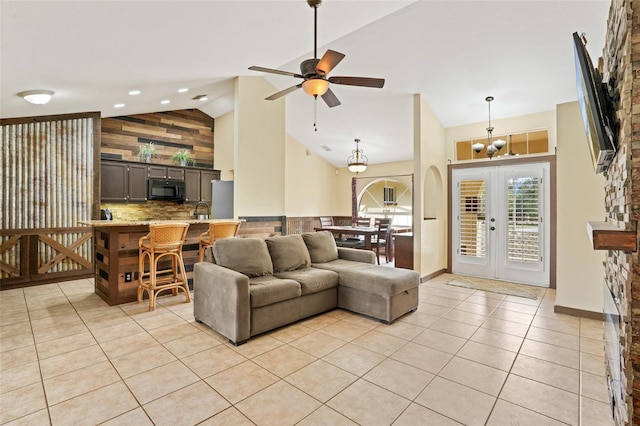 living room with light tile patterned floors, high vaulted ceiling, ceiling fan with notable chandelier, baseboards, and french doors