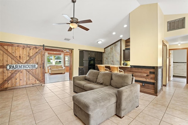 living area featuring light tile patterned floors, a ceiling fan, visible vents, and high vaulted ceiling