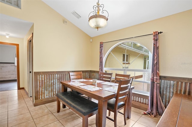 dining space with lofted ceiling, visible vents, and light tile patterned floors