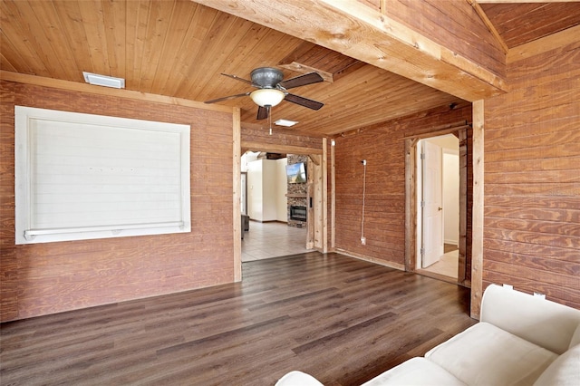 unfurnished living room featuring wooden ceiling, ceiling fan, wood walls, and wood finished floors